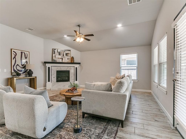 12929 NW 4th St, Yukon, OK 73099 - living area featuring lofted ceiling, light wood-style floors, ceiling fan, and a high end fireplace