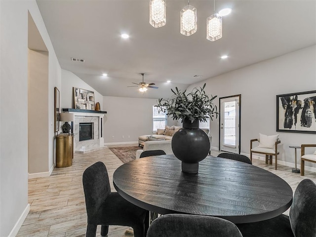12929 NW 4th St, Yukon, OK 73099 - dining area with light wood-style flooring, ceiling fan, lofted ceiling, a fireplace, and recessed lighting