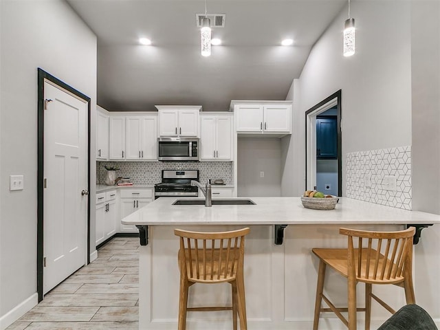 12929 NW 4th St, Yukon, OK 73099 - kitchen featuring stainless steel appliances, tasteful backsplash, white cabinetry, and light countertops