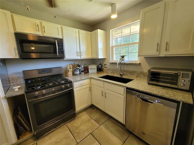 kitchen featuring a sink, white cabinetry, a toaster, and stainless steel appliances