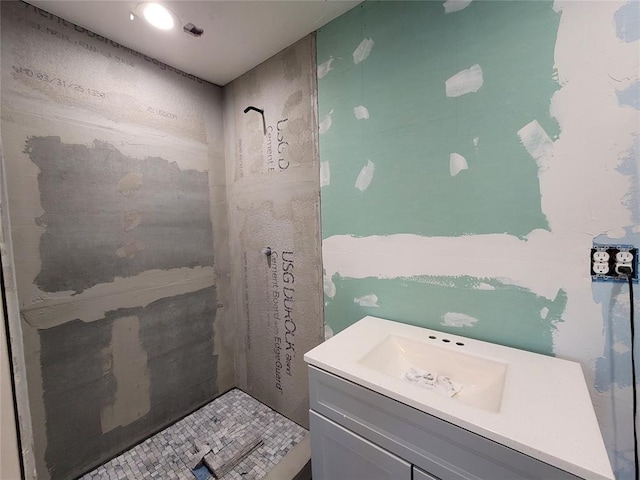 bathroom with vanity and tiled shower
