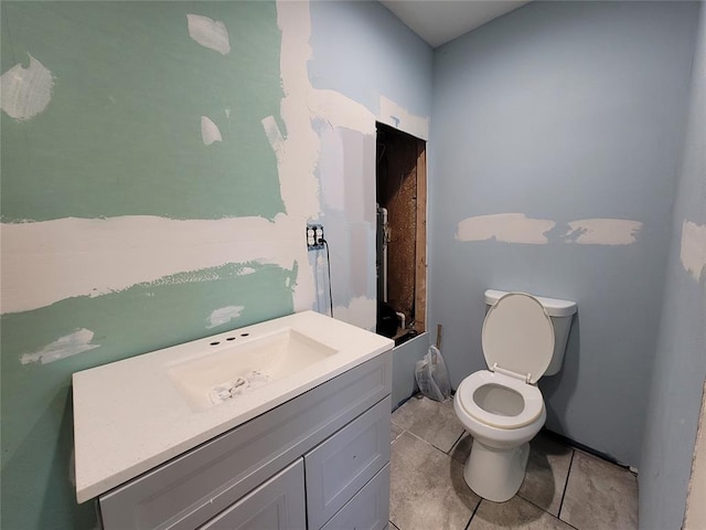bathroom with toilet, tile patterned floors, walk in shower, and vanity