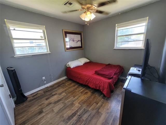 bedroom featuring ceiling fan, visible vents, baseboards, and dark wood-type flooring