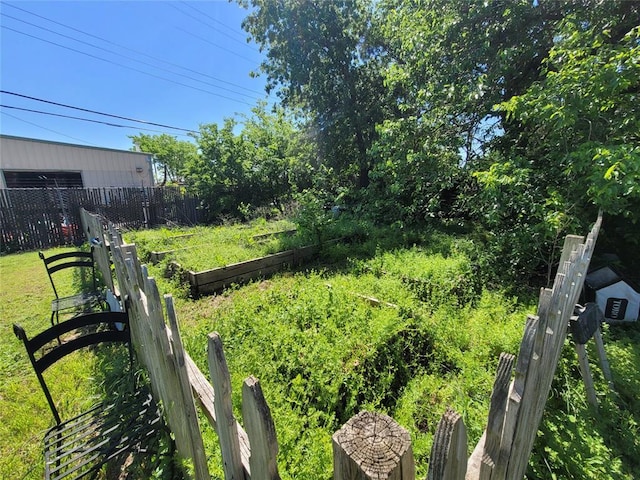 view of yard with fence and a garden
