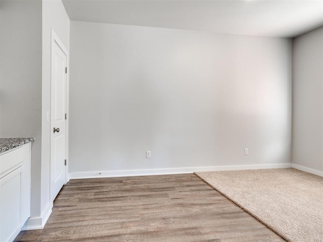empty room featuring light wood-type flooring and baseboards