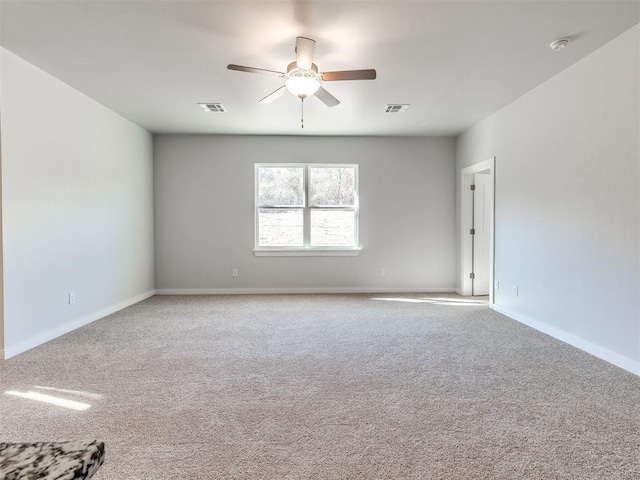 carpeted empty room with visible vents, baseboards, and ceiling fan