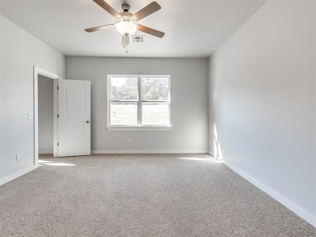 spare room with baseboards, carpet, a ceiling fan, and visible vents