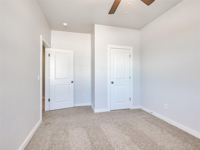 unfurnished bedroom featuring carpet floors, baseboards, and ceiling fan