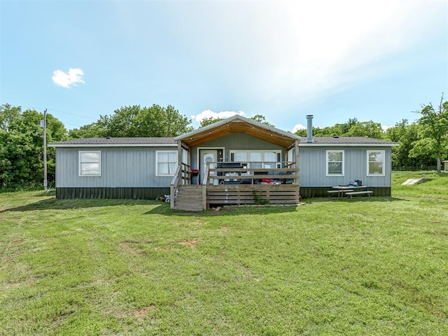 back of house featuring a wooden deck and a yard