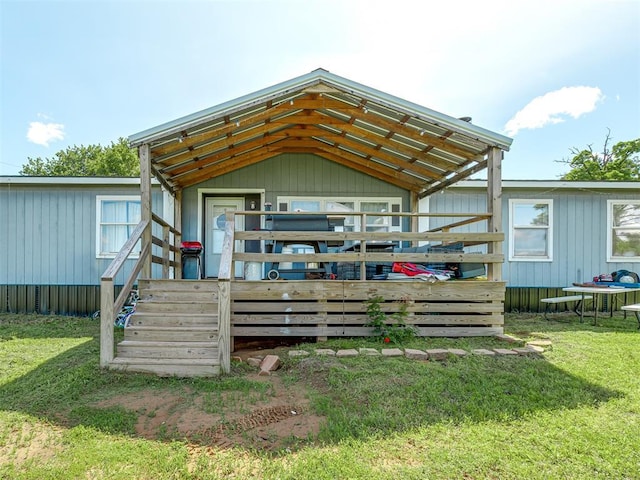 back of property featuring a wooden deck and a yard