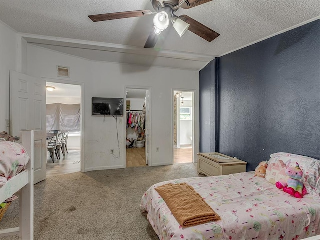carpeted bedroom with visible vents, a ceiling fan, a textured ceiling, and a spacious closet