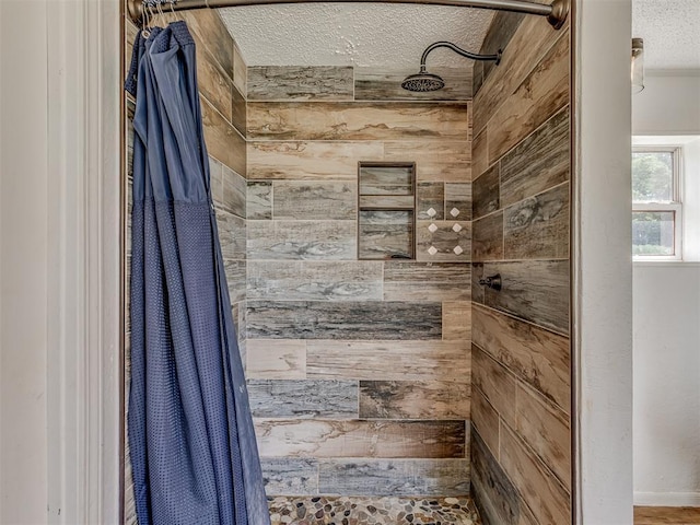 full bath with a tile shower and a textured ceiling