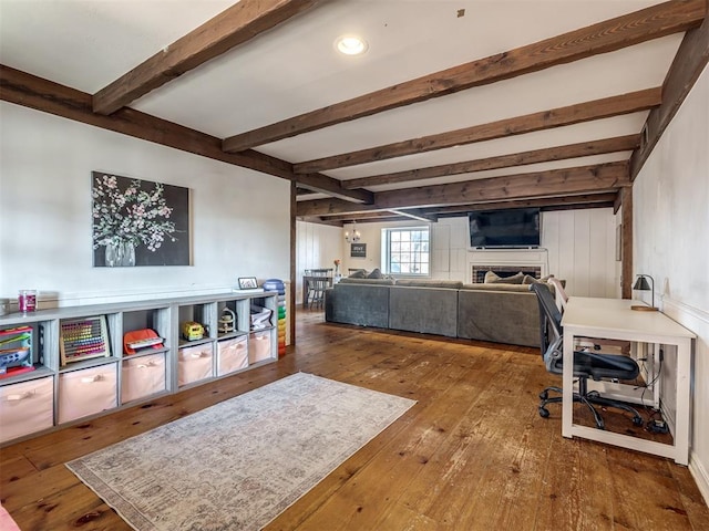 home office featuring wood-type flooring, beam ceiling, and a fireplace