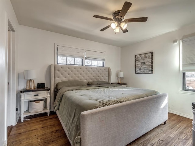bedroom featuring ceiling fan, multiple windows, and wood finished floors