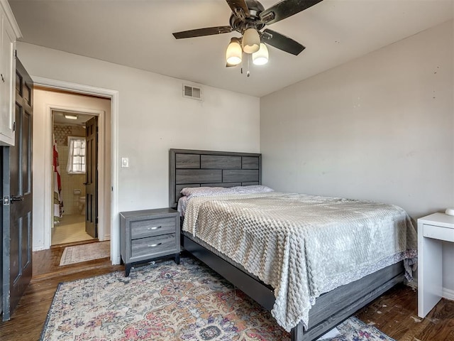 bedroom featuring a ceiling fan, visible vents, and wood finished floors
