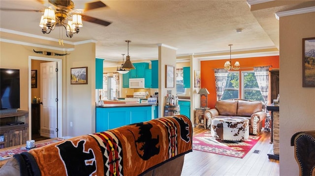 living room featuring crown molding, a textured ceiling, ceiling fan with notable chandelier, and wood finished floors