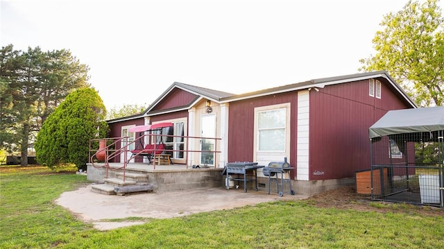 rear view of house with a lawn and a patio