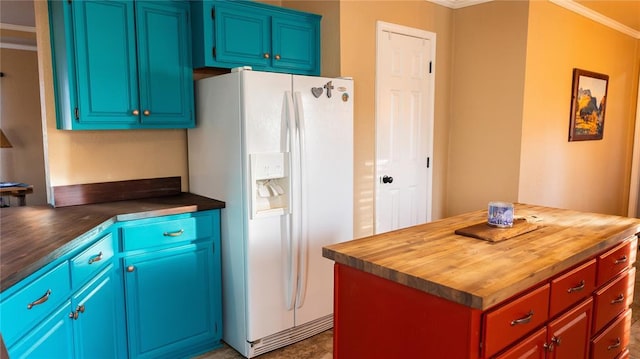 kitchen with crown molding, butcher block counters, and white refrigerator with ice dispenser