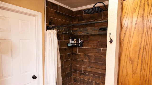 bathroom with crown molding and tiled shower