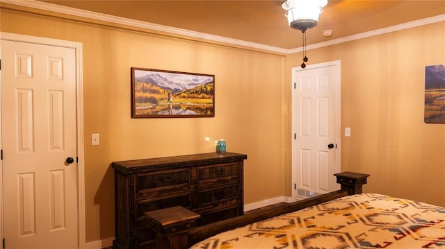 bedroom with baseboards, ornamental molding, and wood finished floors