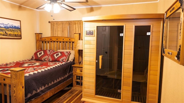 bedroom with crown molding, a sauna, and wood finished floors