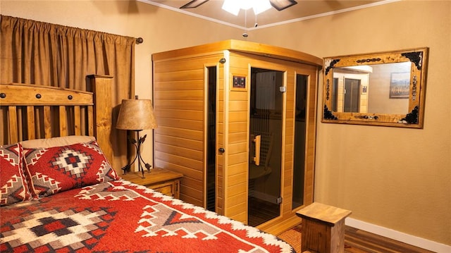 bedroom with ceiling fan, baseboards, wood finished floors, ornamental molding, and a sauna