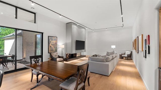 dining room with track lighting and light wood finished floors
