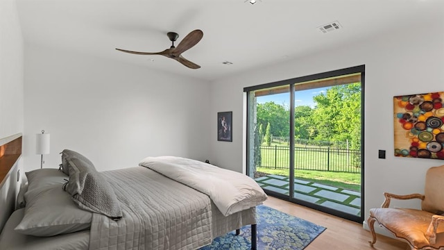 bedroom with access to outside, light wood finished floors, and a ceiling fan