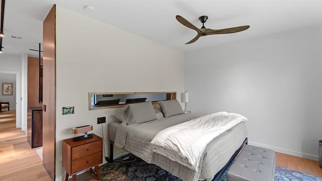 bedroom featuring light wood-type flooring, baseboards, and a ceiling fan