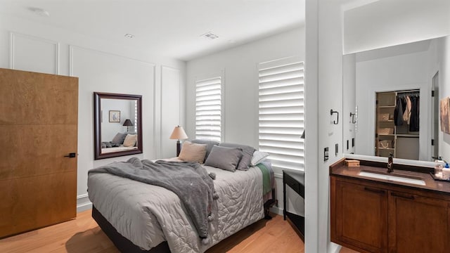 bedroom with a sink and light wood-style flooring