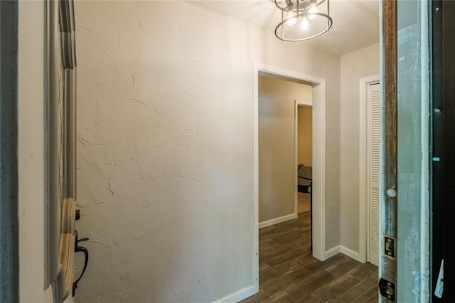 hallway featuring baseboards and dark wood-type flooring
