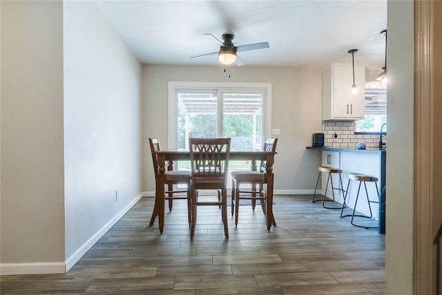 dining room featuring baseboards, a ceiling fan, and dark wood-type flooring