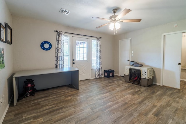 interior space featuring visible vents, baseboards, ceiling fan, and wood finished floors