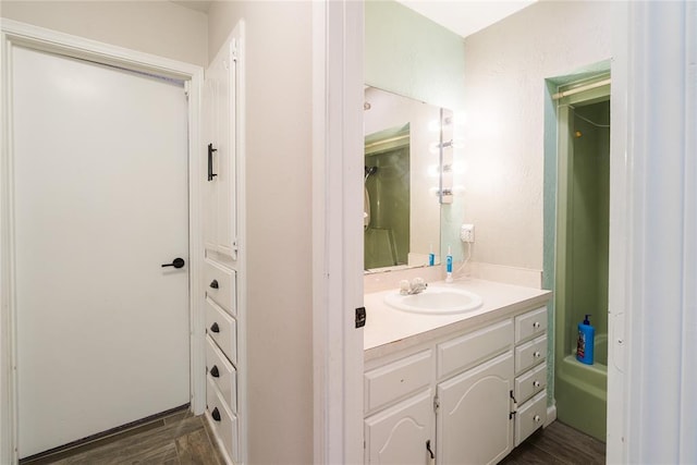 full bath featuring vanity, shower / bath combination, and wood finished floors