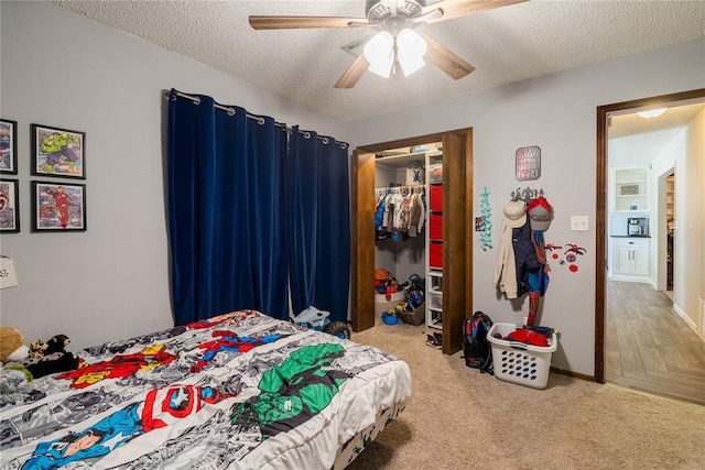 bedroom featuring a ceiling fan, a textured ceiling, carpet, and a closet