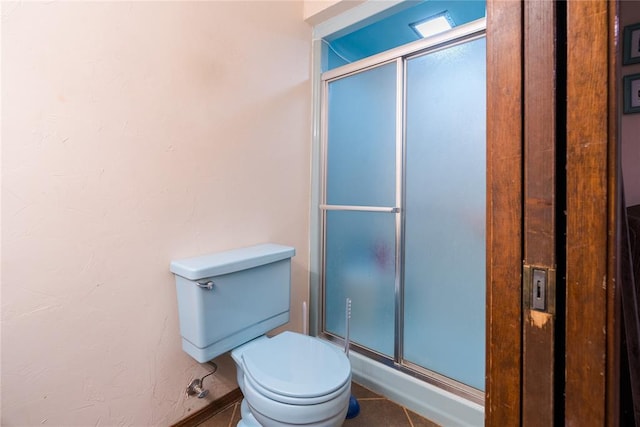 full bathroom with toilet, baseboards, and a stall shower