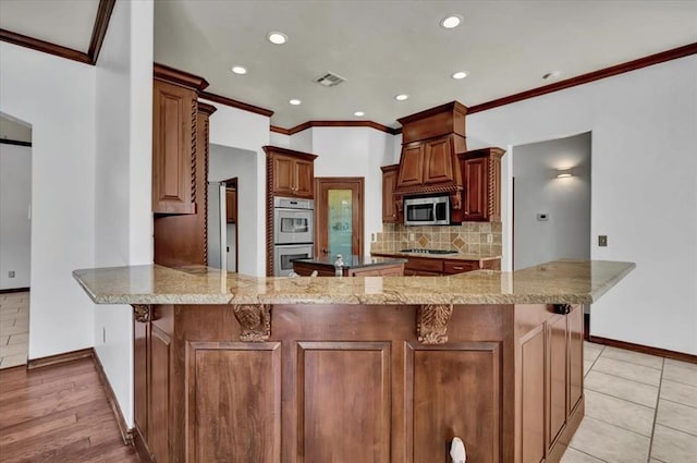 kitchen featuring tasteful backsplash, baseboards, a peninsula, stainless steel appliances, and recessed lighting