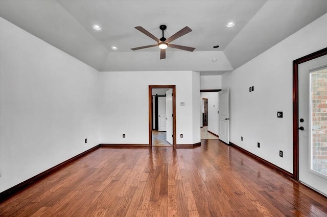 unfurnished bedroom with baseboards, multiple windows, vaulted ceiling, and wood finished floors