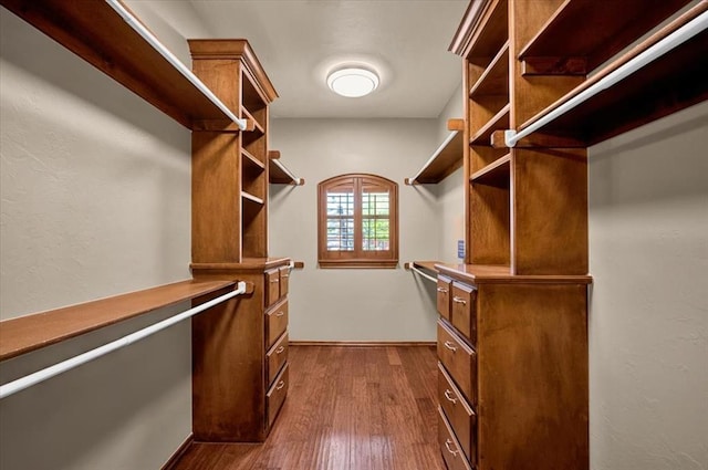 walk in closet with dark wood-type flooring