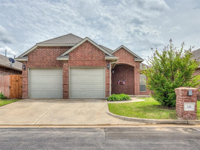 view of front of home with driveway, brick siding, fence, an attached garage, and roof with shingles