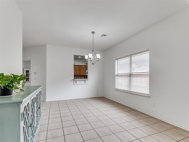 unfurnished dining area featuring an inviting chandelier, baseboards, light tile patterned floors, and visible vents