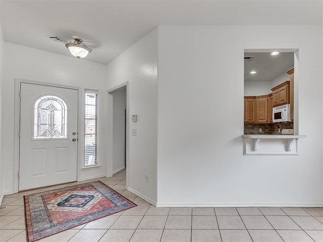 entryway featuring baseboards, light tile patterned floors, and visible vents