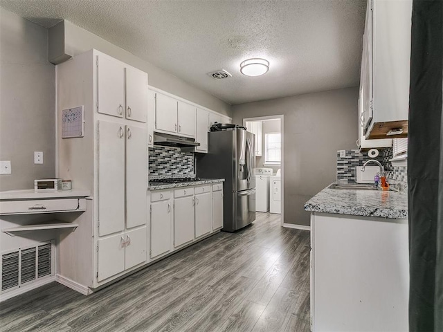 5416 S Independence Ave, Oklahoma City, OK 73119 - kitchen with appliances with stainless steel finishes, a sink, tasteful backsplash, visible vents, and washer and clothes dryer
