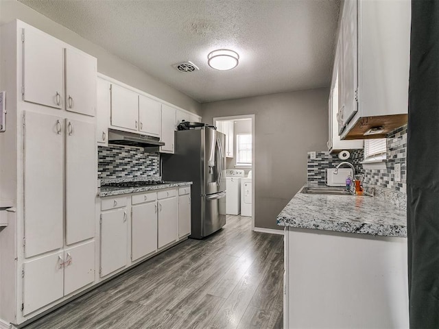 5416 S Independence Ave, Oklahoma City, OK 73119 - kitchen featuring washer and clothes dryer, a textured ceiling, under cabinet range hood, a sink, and stainless steel appliances