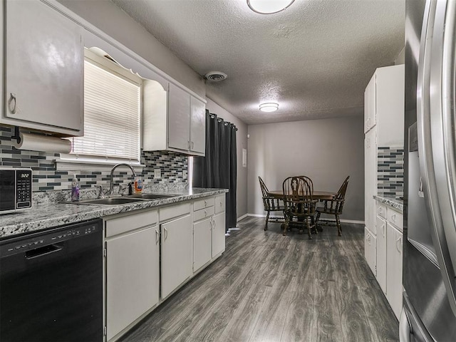 5416 S Independence Ave, Oklahoma City, OK 73119 - kitchen featuring dark wood-type flooring, a textured ceiling, tasteful backsplash, a sink, and dishwasher