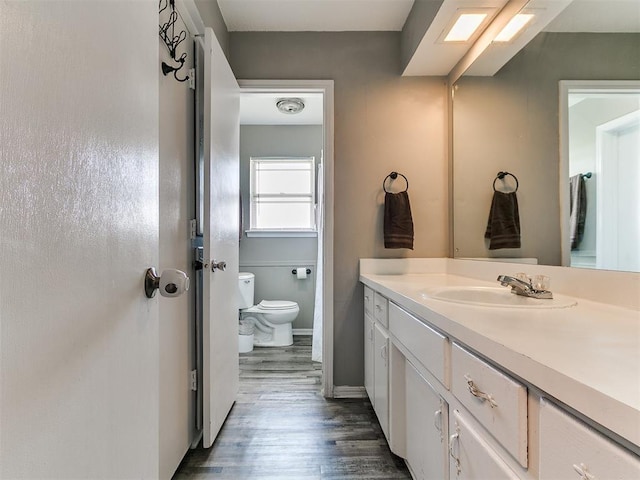 5416 S Independence Ave, Oklahoma City, OK 73119 - bathroom with vanity, baseboards, wood finished floors, and toilet