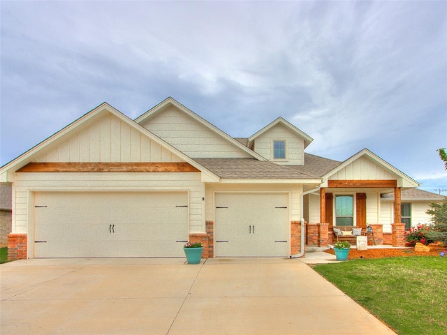 view of front of home with a porch, an attached garage, concrete driveway, and brick siding