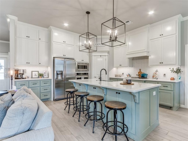 kitchen with appliances with stainless steel finishes, a sink, open floor plan, backsplash, and recessed lighting