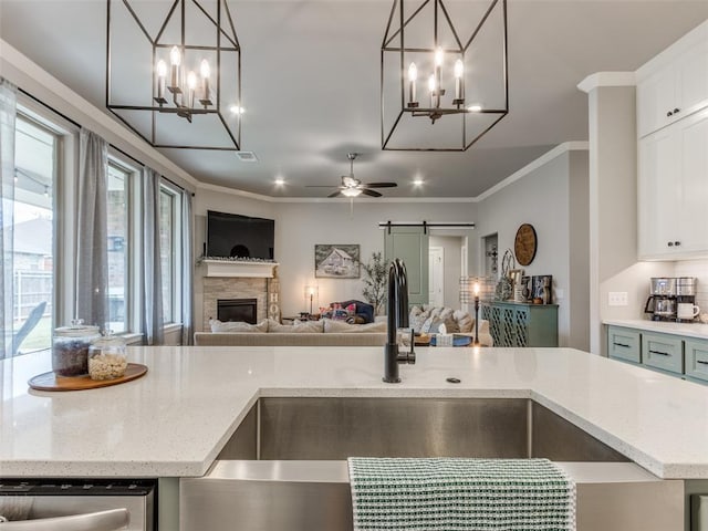 kitchen featuring a chandelier, open floor plan, a sink, dishwasher, and crown molding