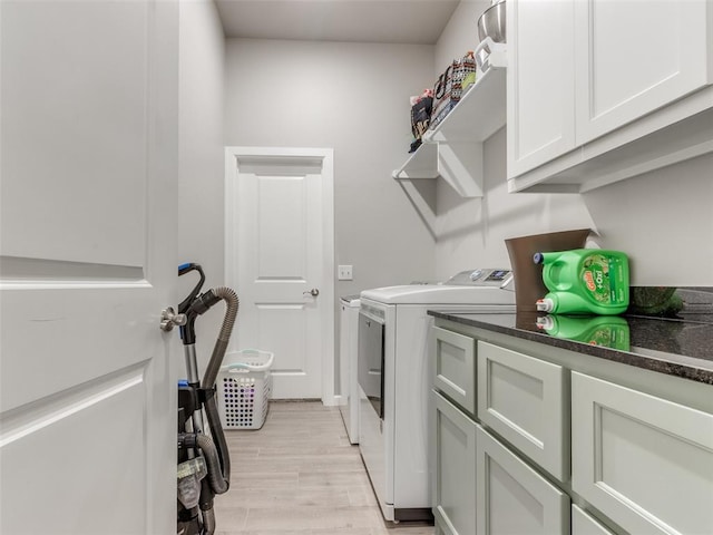 laundry area with washing machine and dryer, light wood-style flooring, and cabinet space
